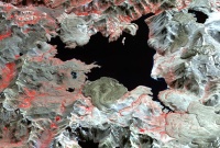 False color ASTER image of Laguna del Maule (vegetation is in red) on April 9, 2003, showing some of the rhyolite lava flows and domes around the lake. Image: NASA Earth Observatory.